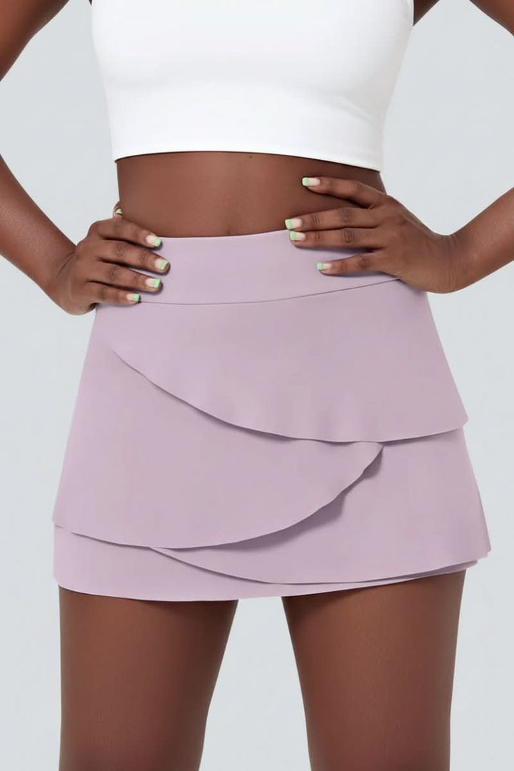 Athletic women's tiered golf skort, high-performance activewear with built-in shorts and stylish design.