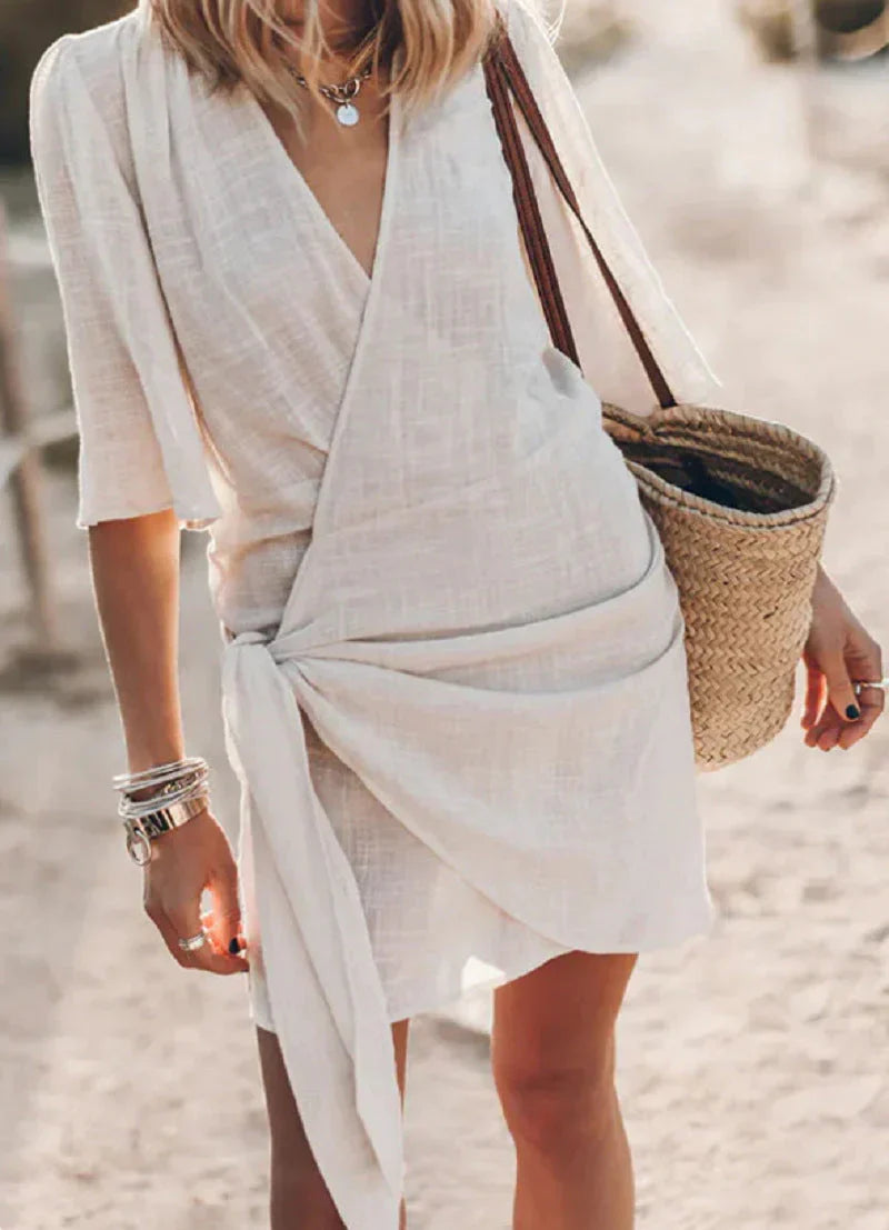 Fashionable women's mini dress featuring a V-neck and elegant draped silhouette, perfect for summer style.