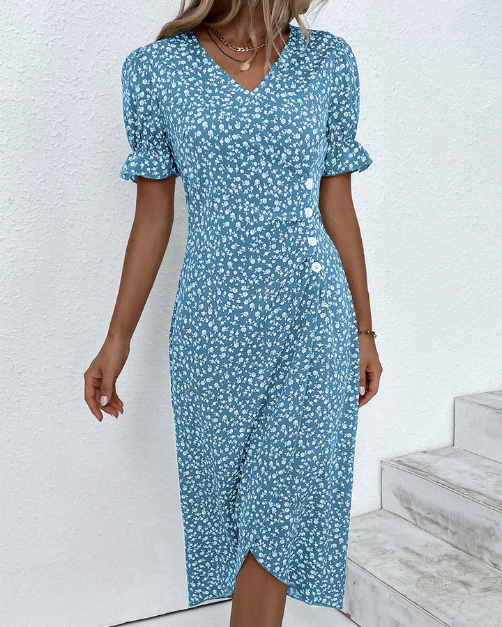 Women's floral V-neck flowy summer midi dress worn outdoors in a garden setting. Casual elegant spring outfit.