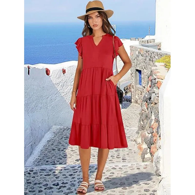 Woman wearing a flattering V-neck tiered midi dress with flutter sleeves, suitable for warm weather fashion.