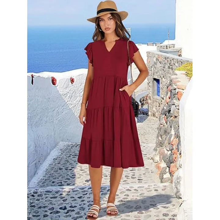 Close-up of a women's V-neck tiered midi dress, highlighting the intricate tiers and airy flutter sleeves.
