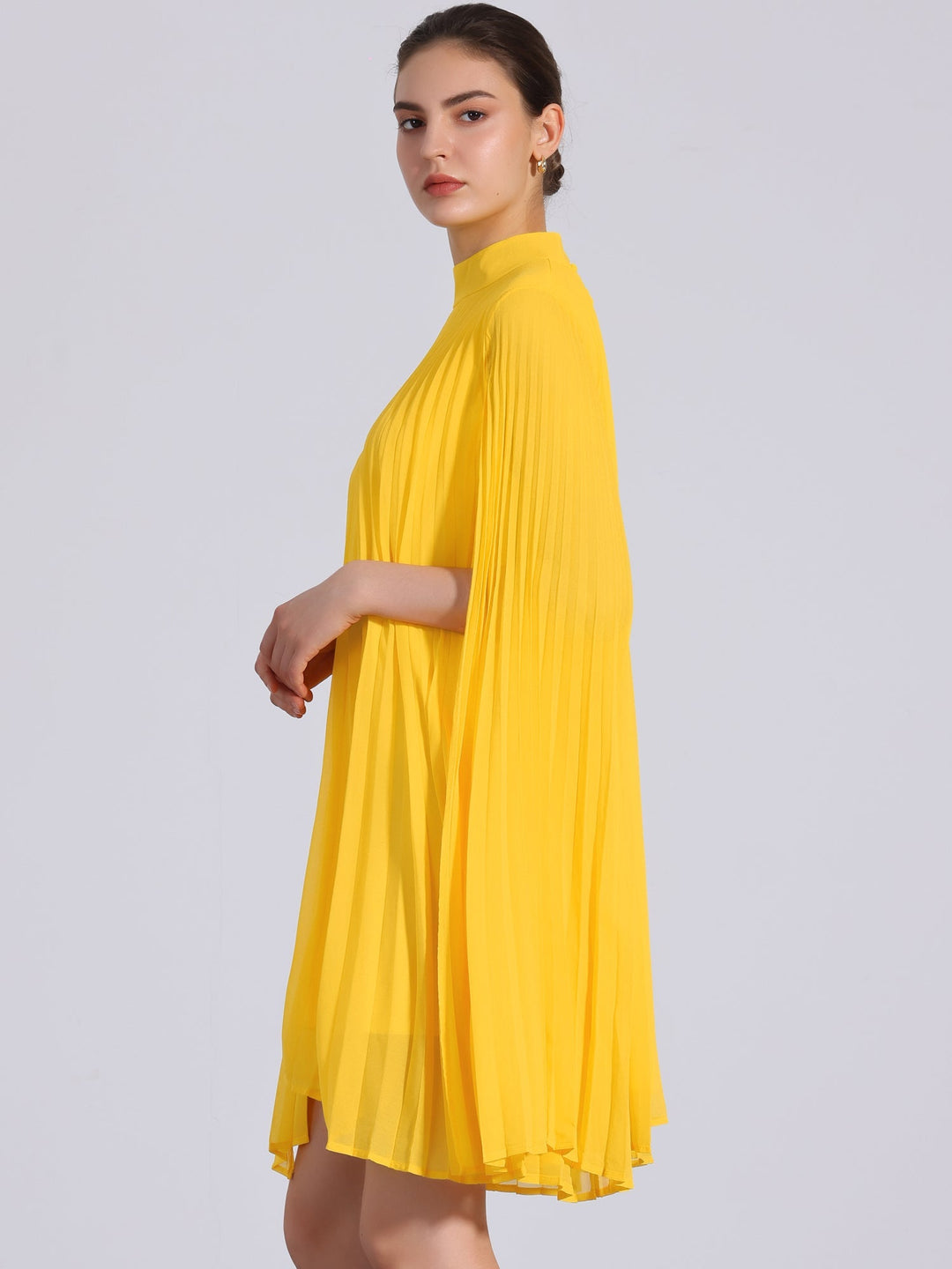 Effortless yellow women's dress: pleated swing style, mock neck, and flowing cape sleeves for a comfortable, chic look.