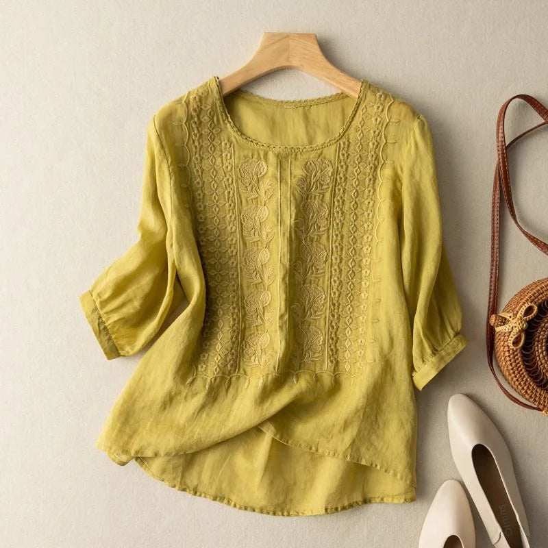 Close-up of the intricate embroidery on a women's vintage blouse with stylish puff sleeves and round neck.