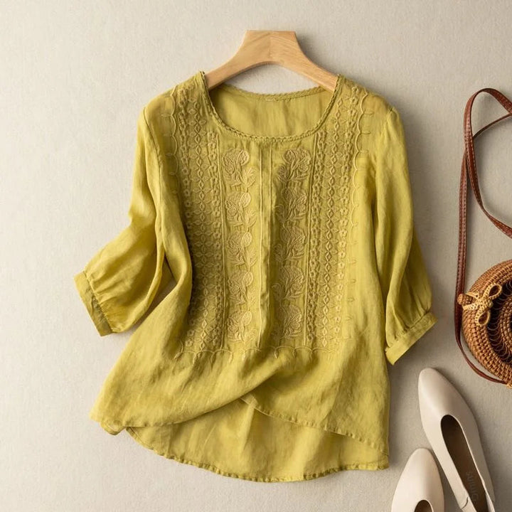 Close-up of the intricate embroidery on a women's vintage blouse with stylish puff sleeves and round neck.