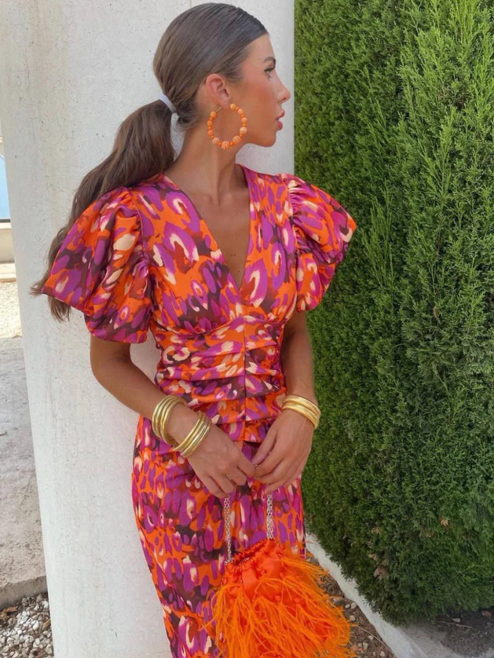 Elegant women's midi dress featuring vibrant abstract print, flattering ruching, and unique sculpted pleats.