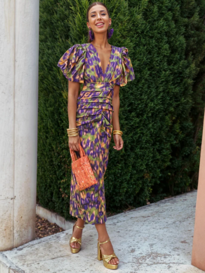 Elegant women's wedding guest midi dress with vivid abstract print, ruched details, and sculpted pleats.