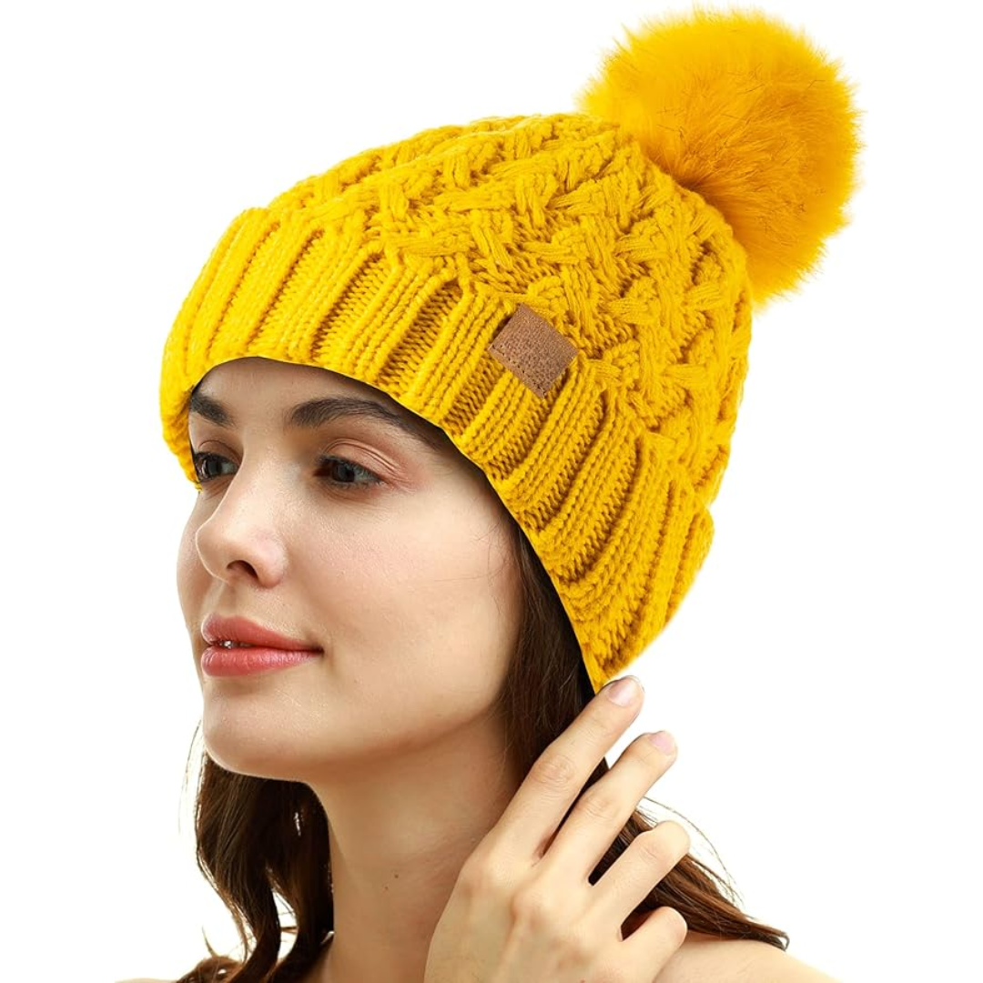 Women's warm cable knit winter beanie with a fluffy pom-pom.