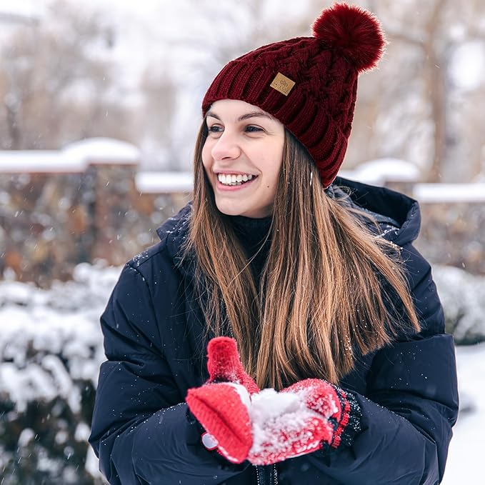 Fluffy pom-pom on women's warm cable knit winter beanie, cozy fleece lining inside.