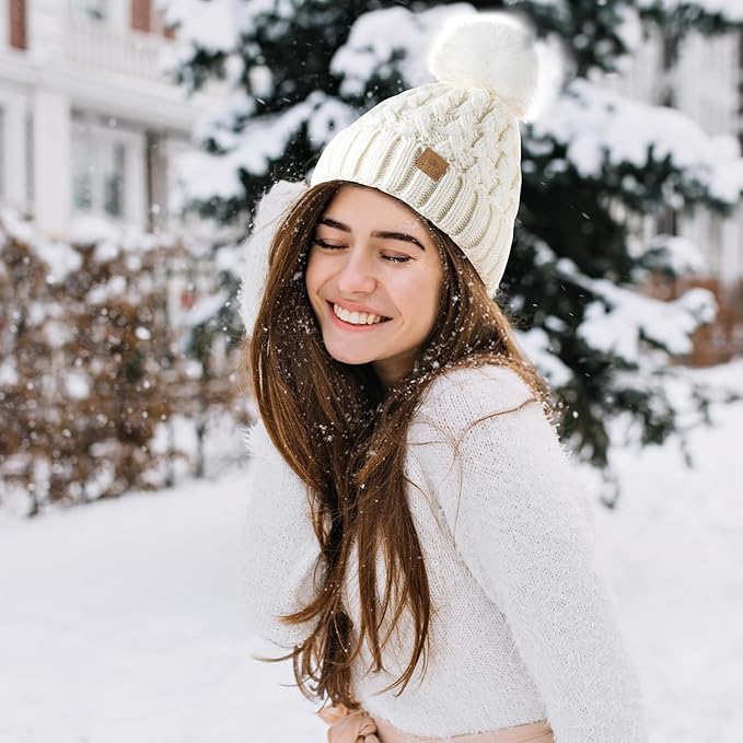 Warm women's knit beanie with cable pattern, comfy fleece lining, and a playful pom-pom.