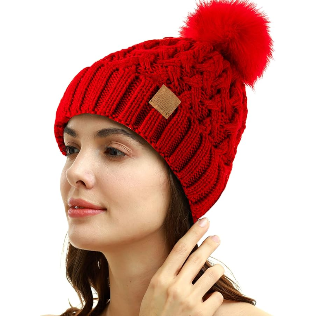 Soft cable knit women's beanie, fleece-lined for warmth, topped with a playful pom-pom.