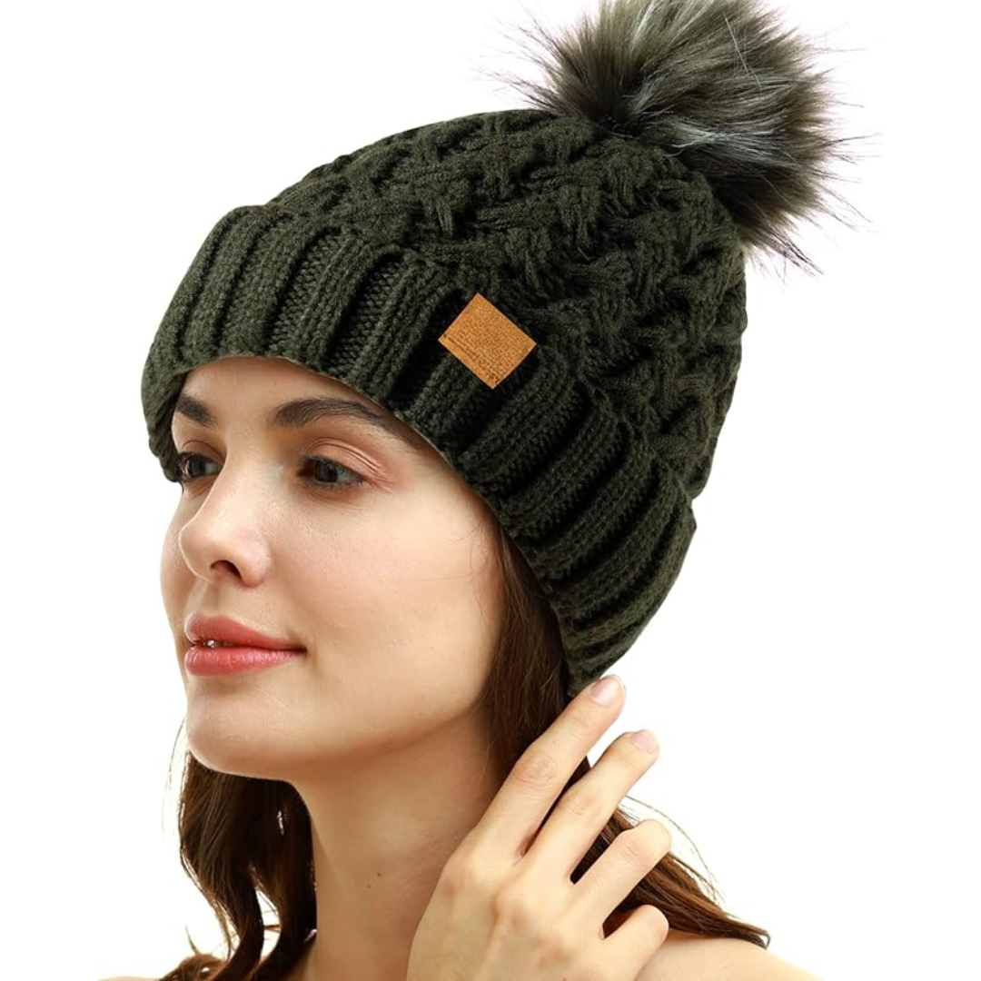Essential women's winter hat: warm cable knit beanie, fleece-lined, with a plush pom-pom.