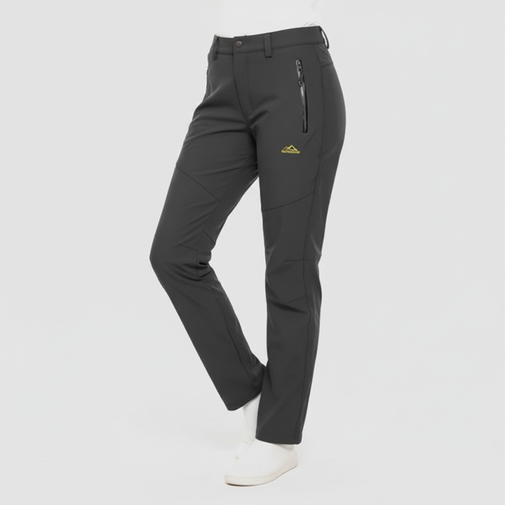Woman hiking in comfortable Lydia waterproof insulated outdoor pants. Ideal activewear for cold weather exploration.