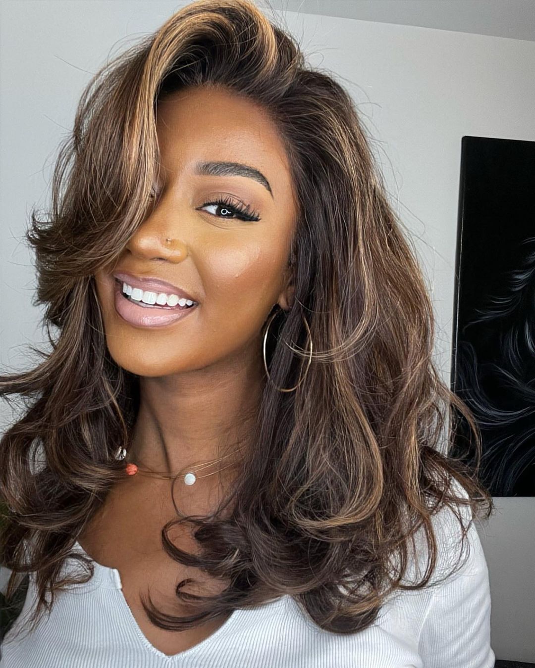 Women's wavy human hair lace front wig in dark brown with blonde highlights, natural look.
