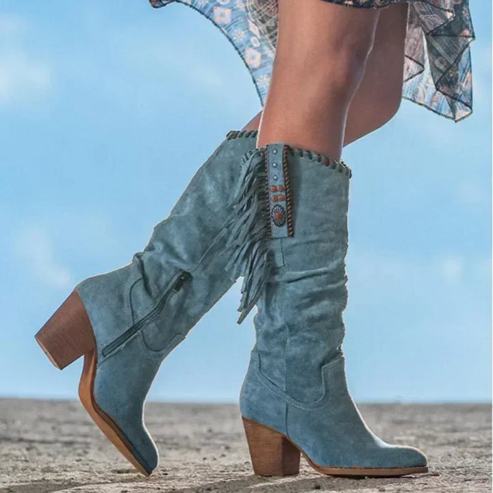 Designer women's mid-calf Western boots, crafted with elegant fringe and vibrant turquoise stud details.