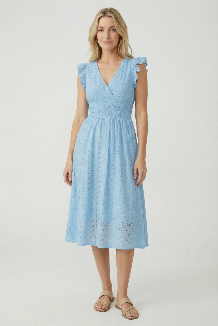 Woman walking in a flowy flared eyelet midi dress, showing off ruffled sleeves and comfortable summer style.