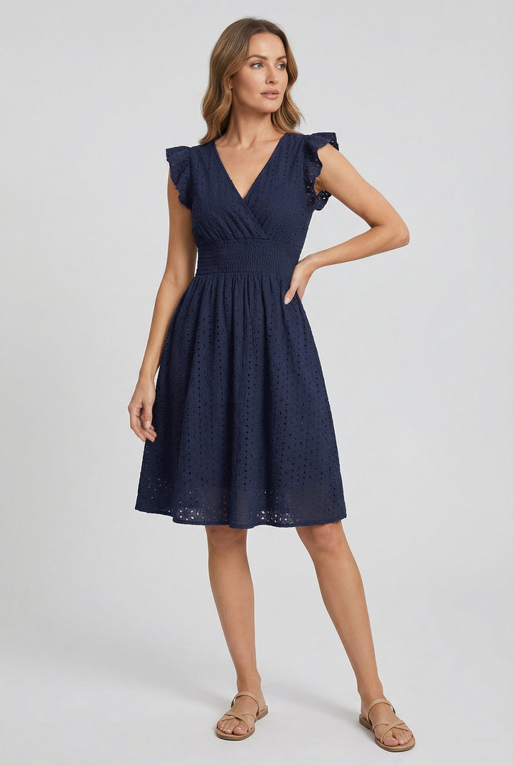 Flowy flared hem of a women's eyelet midi dress, designed for comfortable movement in warm summer weather.