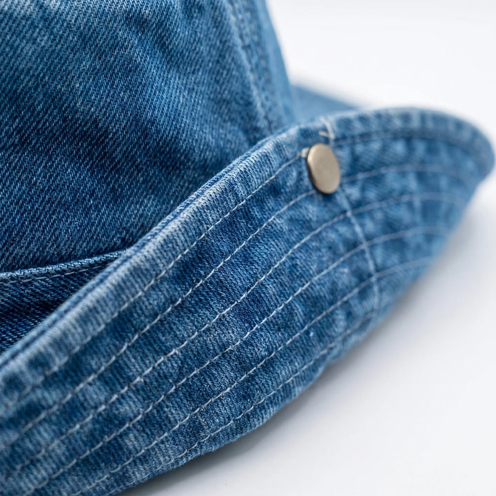 Dark blue women's wide brim outdoor bucket hat, adjustable for travel, beach & sun protection, a stylish summer accessory.