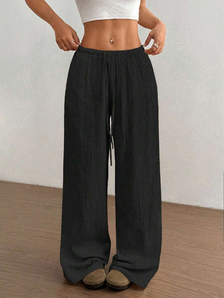 Bohemian style women's wide leg pants, crinkle texture, drawstring elastic waist. Relaxed summer fashion.