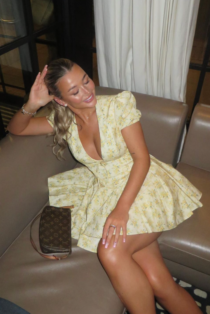 Vibrant yellow floral mini dress with puff sleeves & open back. A trendy summer fashion piece.