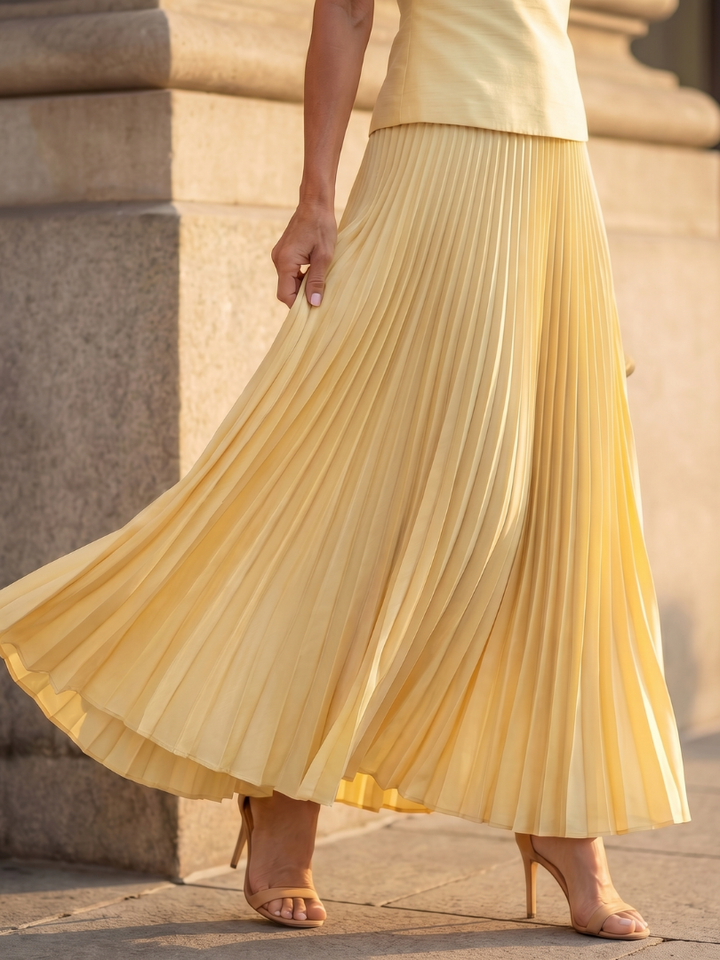 Pink elegant women's coordinated set with a structured top and a pleated maxi skirt, special occasion.