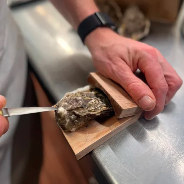 Wooden oyster shucking clamp for safe, effortless seafood opening.