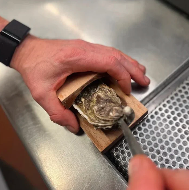 Essential wooden oyster shucking clamp, a safe kitchen tool for seafood lovers.