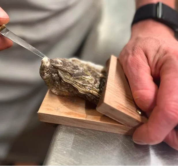 Effortless oyster shucking with this safe wooden clamp, a must-have kitchen accessory.