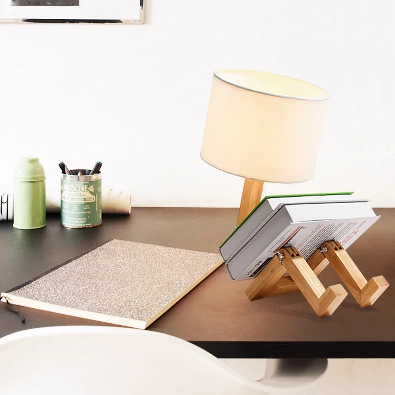 Charming wooden robot desk lamp with a built-in book holder, ideal for reading and enhancing modern decor.