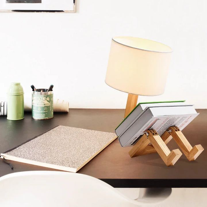 Charming wooden robot desk lamp with a built-in book holder, ideal for reading and enhancing modern decor.