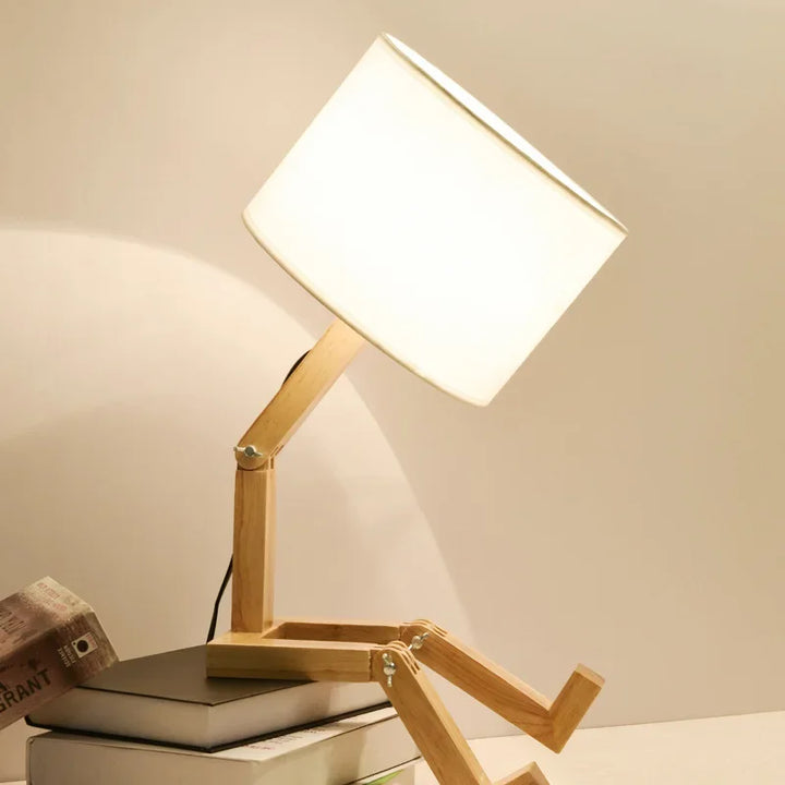 Stylish wooden robot reading lamp with an integrated book holder, a unique decorative piece for modern desks.